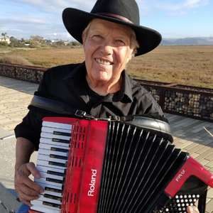 Photo of John Chambers wearing a hat and playing the accordion