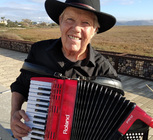 Photo of John Chambers wearing a hat and playing the accordion